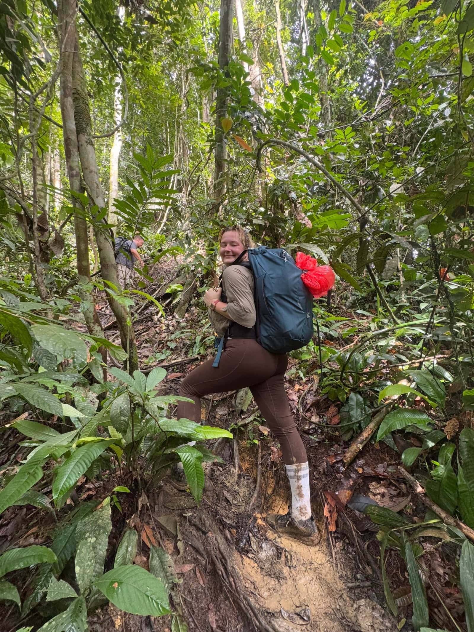 jungle woman trekking in sumatra with backpack looking for orangutan