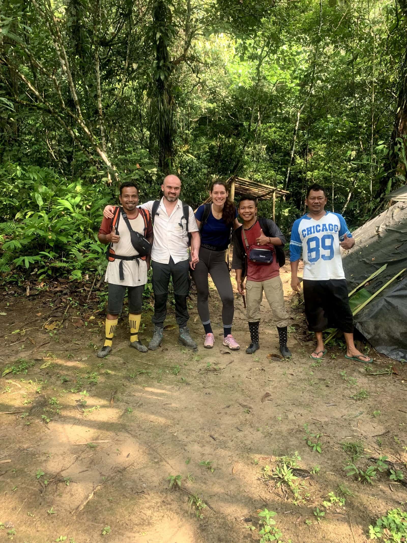 Group trekking in sumatran jungle looking for orangutan