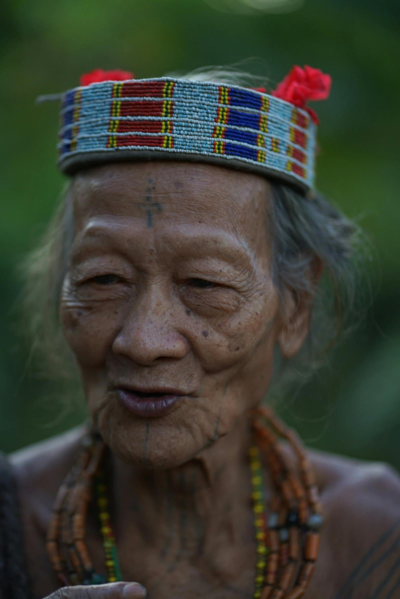 Portrait of a Mentawai elder wearing a colorful traditional headband in West Sumatra, Indonesia.