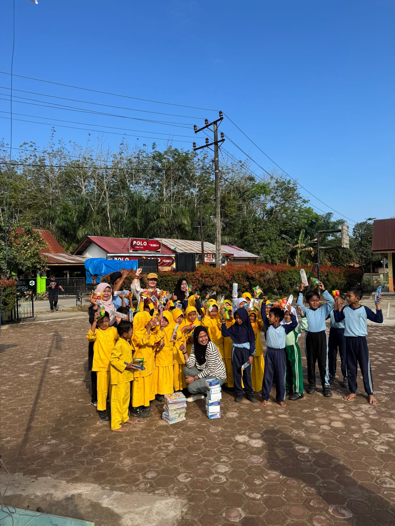 A photo of the kids at the 3 schools with their new uniforms or school supplies.