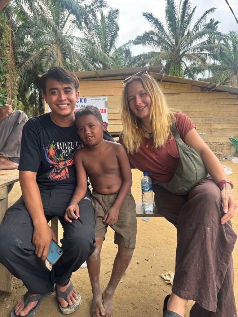 Children in a remote village smiling after receiving school supplies and uniforms during our Aceh Relief Mission.